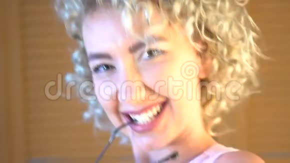 一位留着短卷发的漂亮女孩的肖像正在家里跳舞视频的预览图