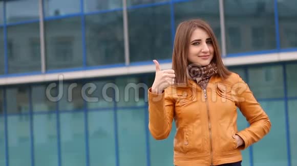 美丽的年轻白种人女人微笑着伸出大拇指在城市的户外视频的预览图