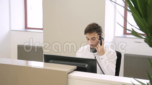 男雇员在打电话然后女雇员在办公室里接近他视频的预览图