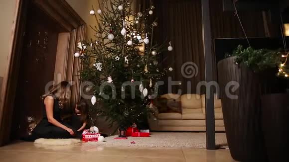 圣诞树闪烁着灯光妈妈和女儿一起装饰圣诞树水平摄像机移动视频的预览图