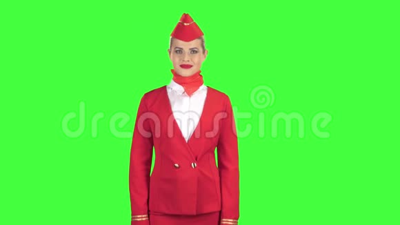 穿着红色西装的女乘务员眨了眨眼睛轻轻地调情发出一个吻绿色屏幕视频的预览图
