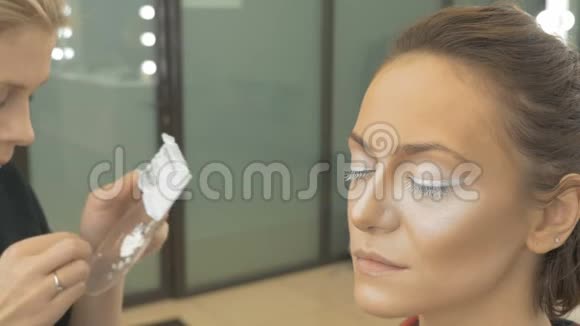 专业化妆师涂抹人造睫毛的模型艺术摄影的准备特写视频的预览图