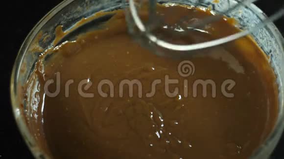 为圣诞节制作糖果的巧克力与黑色背景的奶油搅拌器混合视频的预览图