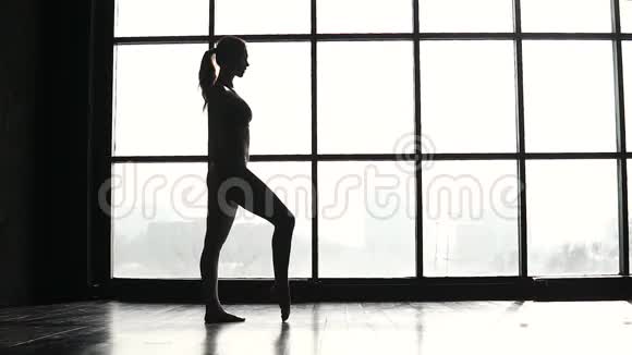 体操运动员的剪影用麻绳在空中翻筋斗穿运动装的灵活的女孩慢动作视频的预览图