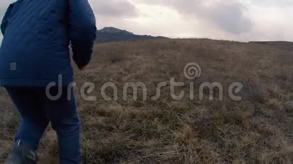 山坡上的一个男孩带着薄雾跑到山上慢速视频视频的预览图