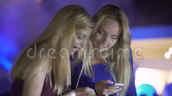 在聚会上使用智能手机的女性朋友在网上聊天脸上露出微笑视频的预览图