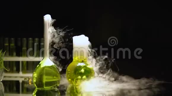 烧瓶中的化学液体在黑暗中冒泡并散发烟雾反应视频的预览图
