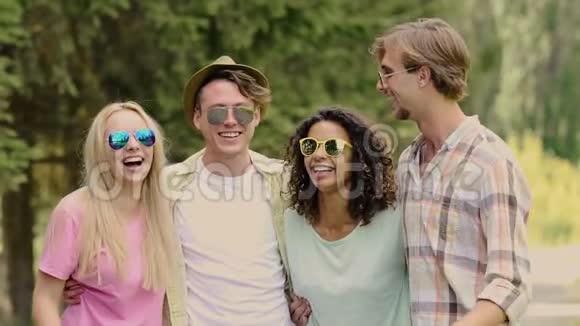一群快乐的年轻人拥抱着笑着在公园里玩得开心视频的预览图