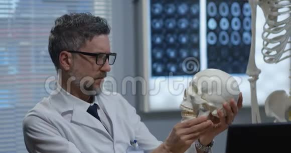 男性医生分析人体骨骼模型视频的预览图