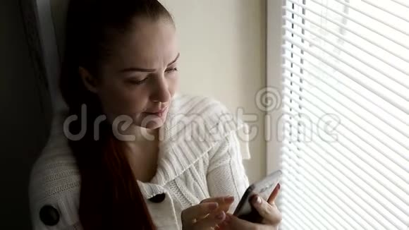 数字技术和通信中年妇女在智能手机屏幕上浏览互联网网站坐在旁边视频的预览图