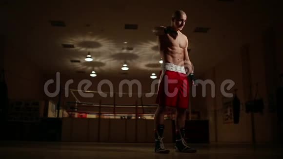 一个职业拳击手在拳击台的背景下在拳击前屈手视频的预览图