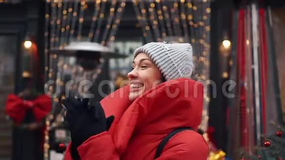 微笑的女人在一个古老城市的街道上用圣诞装饰在门前跳舞视频的预览图
