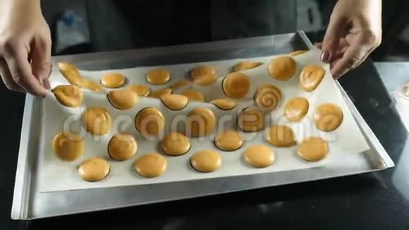 烹制马卡龙法式甜点的过程羊皮纸上五颜六色的马卡龙烤炉前的准备工作视频的预览图
