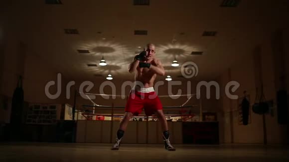 一个职业拳击手在戒指的背景下花费影子拳击相机的移动Stadicam视频的预览图