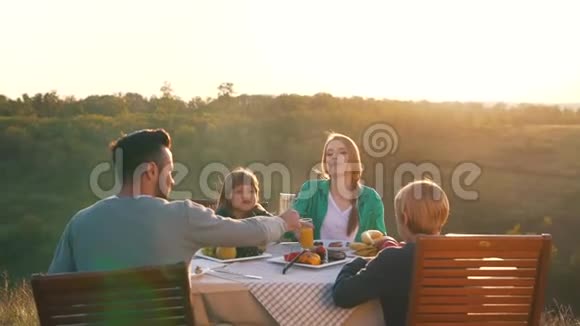 幸福的家庭在美丽的乡村吃晚餐视频的预览图