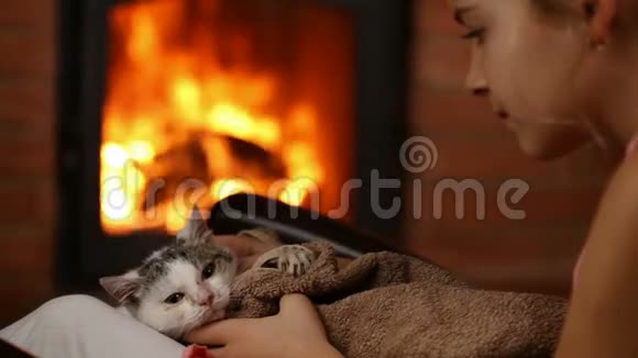带着救援小猫的小女孩在壁炉旁视频的预览图