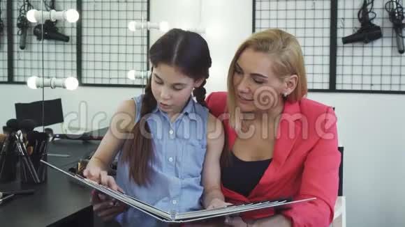 小女孩在美容院帮妈妈选调色板上的发色视频的预览图