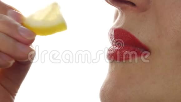 女人吃多汁的柠檬特写嘴唇4K视频的预览图