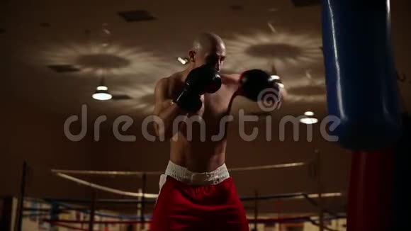 一个穿着拳击鞋和短裤的男人在体育馆里打拳击肖像特写视频的预览图