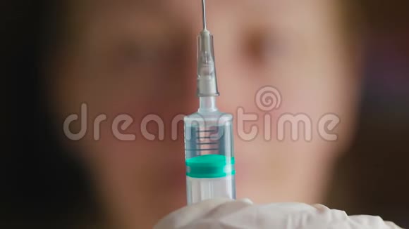 一位女医生面部模糊用针头集中注射器液体泄漏视频的预览图