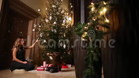 妈妈和女儿用玻璃圣诞树装饰圣诞树视频的预览图