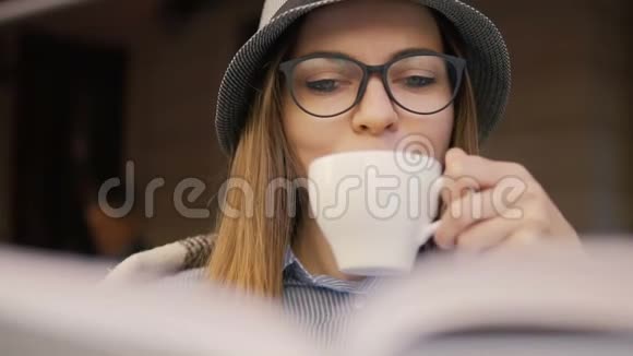 女孩在户外咖啡厅阅读书籍视频的预览图