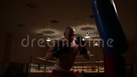一个职业拳击手在一个拳击手梨子上进行训练因为他的拳打脚踢视频的预览图