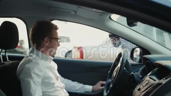 男人司机用手机付出租车钱NFC技术公路或燃料付款视频的预览图