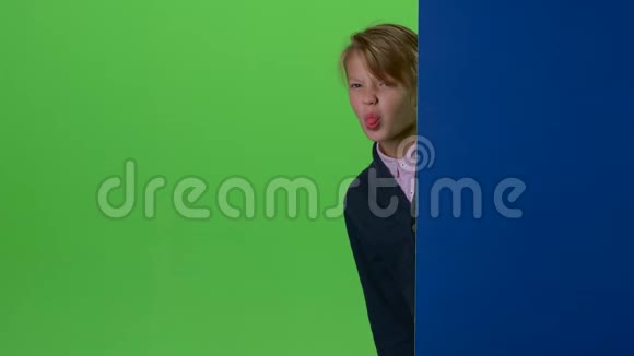 少年在绿色的屏幕上从背后和木板的曲线上窥视视频的预览图