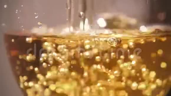 在玻璃杯中缓慢地倒入带有气泡的黄色饮料视频的预览图