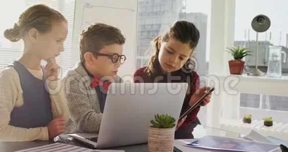 儿童作为企业高管使用笔记本电脑和数码平板电脑视频的预览图