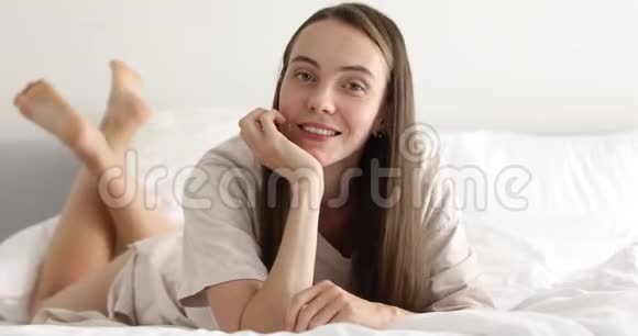 性感的年轻女人躺在床上视频的预览图