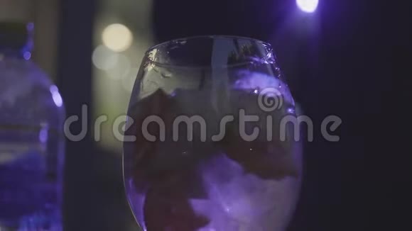 在黑暗的背景下用柑橘片装饰的冰块来喝一杯白葡萄酒框架搅拌白色视频的预览图