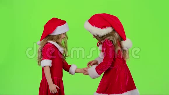 穿红色西装的小女孩玩游戏微笑玩得开心绿色屏幕慢动作视频的预览图