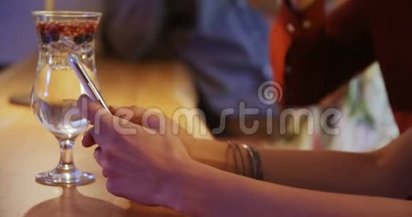 一对夫妇在酒吧柜台用手机视频的预览图