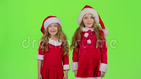 穿红色西装的孩子们站在房间里眨眼绿色屏幕视频的预览图