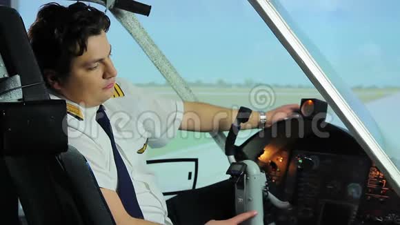 坐在驾驶舱里的飞行员工作过度梦想着度假辛勤工作视频的预览图