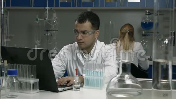 实验室里用管子工作的男科学家视频的预览图