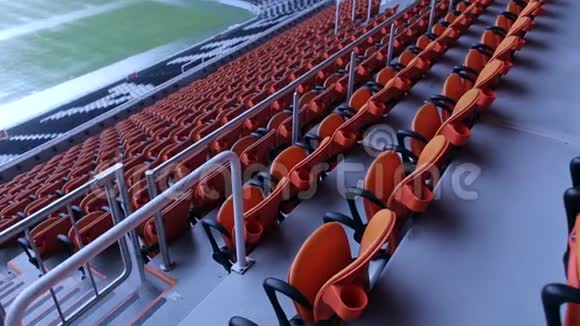 体育场竞技场座椅一排排橙色观众坐在体育场里视频的预览图