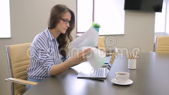 在办公室里女人看着笔记本电脑上有图表和指纹的文件视频的预览图