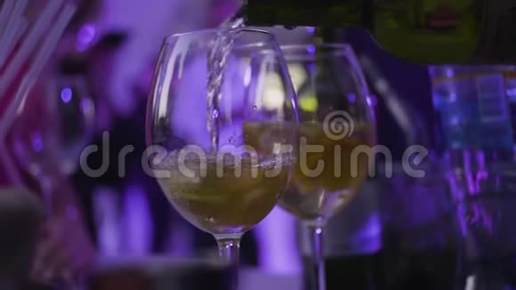 特写酒杯倒白葡萄酒在夜总会框架将含酒精的饮料倒入玻璃杯中用于夜间聚会视频的预览图