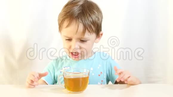 这孩子拒绝喝茶这个男孩对食物不满意孩子用手推着杯子视频的预览图