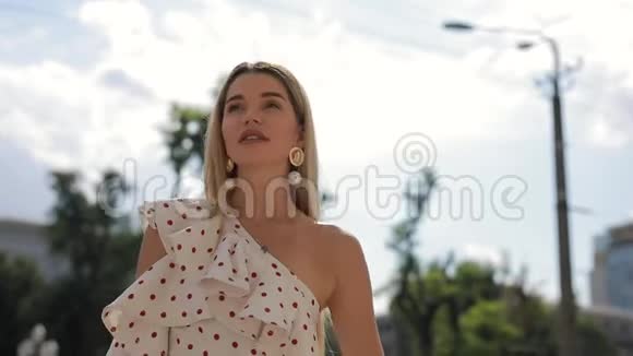 美丽优雅的女人穿着礼服摆着夏城的姿势视频的预览图