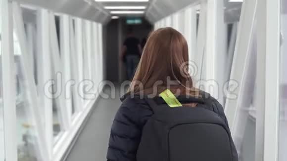 Steadycam拍摄的一名妇女在连接机场和飞机的走道内行走视频的预览图