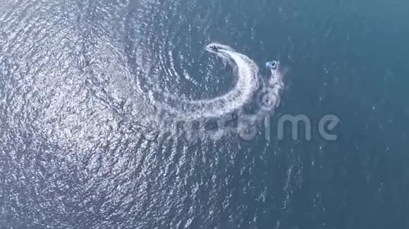 俯视图慢动作水上摩托车在海浪中穿行在蔚蓝的大海上翻滚着人们对水的吸引力视频的预览图