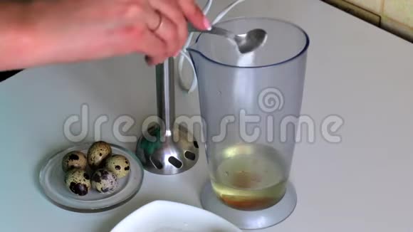做蛋黄酱搅拌机碗里的鹌鹑蛋女人添加其他成分视频的预览图