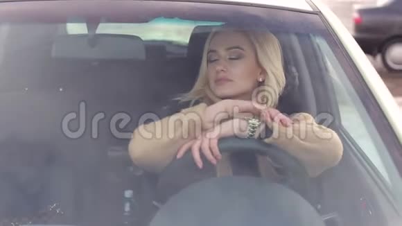 坐在车里靠在方向盘上的漂亮女孩视频的预览图