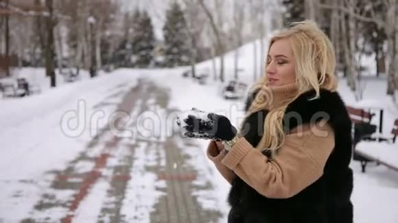 冬天的女孩在公园里吹雪特写镜头视频的预览图