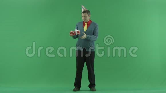 成熟的男人看他的生日礼物绿色的关键背景视频的预览图