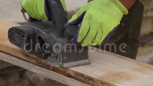 用木板电动刨床工作的男性手慢动作视频的预览图